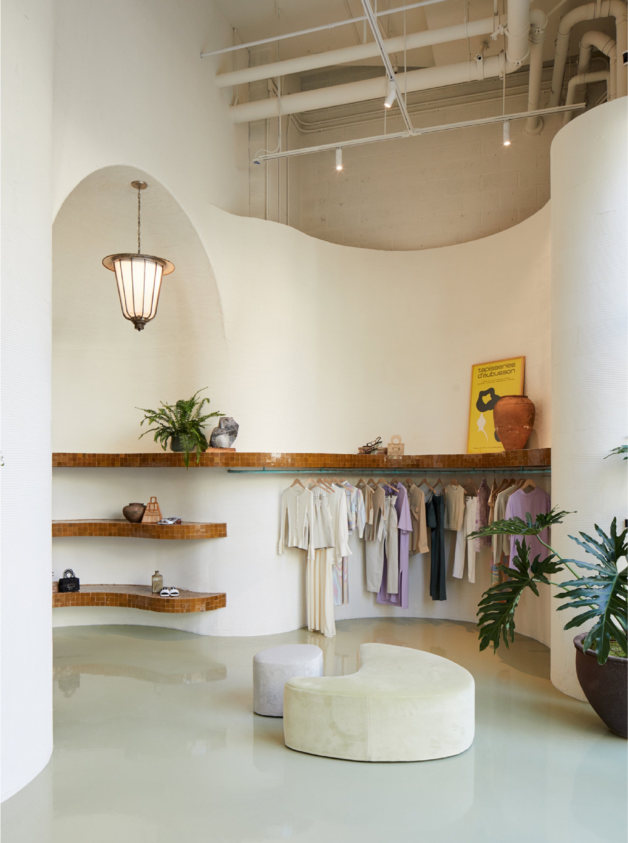 interior photo of Teller Shop showing a rack of clothes, shelves and a bench.